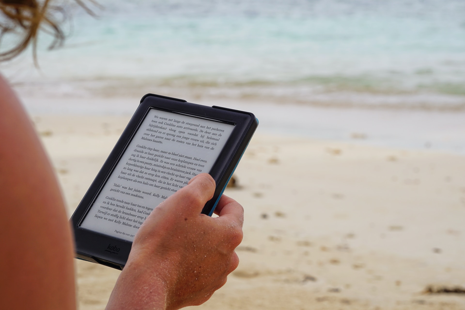 pessoa lendo na praia e-books grátis baixados na Amazon conforme nosso tutorial